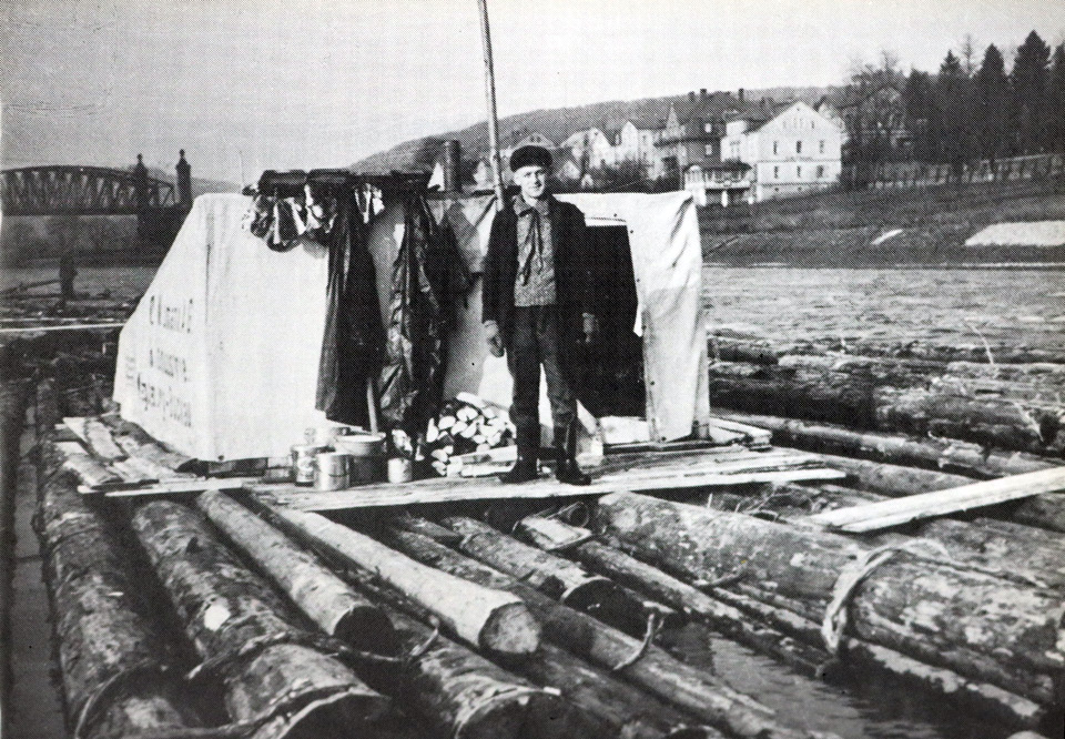 Der Floßherr steht vor der provisorisch aufgebauten Hütte auf dem Floß